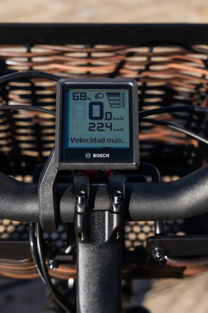 Primer plano de un velocímetro de bicicleta Bosch que indica 6 km/h y 68 % de batería, con texto en español. Esta Riese & Müller Swing4 Silent muestra la combinación perfecta de diseño de bicicleta eléctrica urbana y elegancia de estilo holandés.